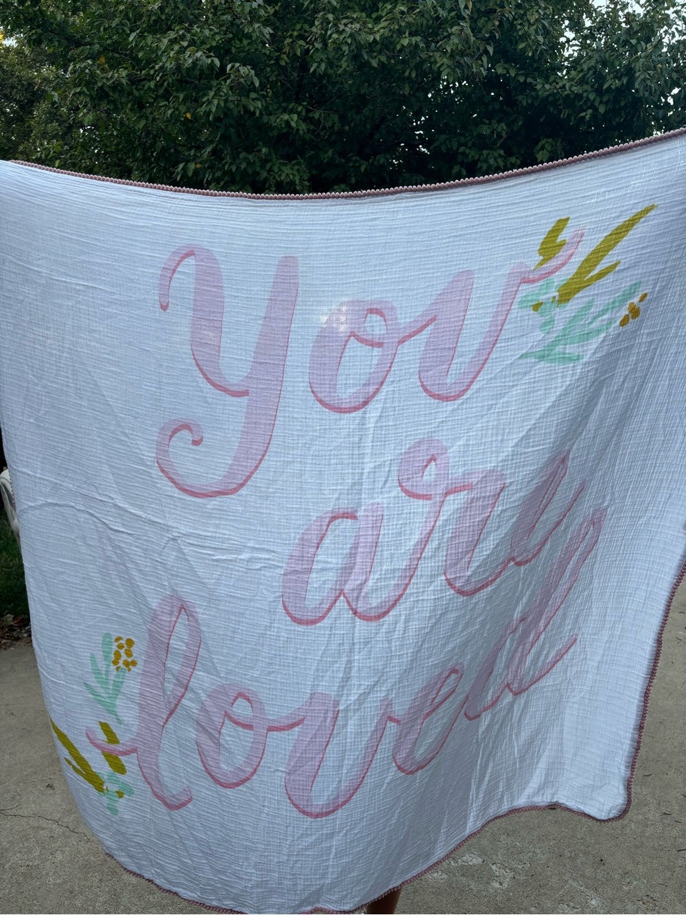 You Are Loved Pink Script Muslin Baby Blanket has a light stain